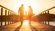Senior couple holding hands while walking across a bridge during the sunset