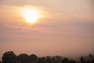 Wall Mural - sunset over the village and trees