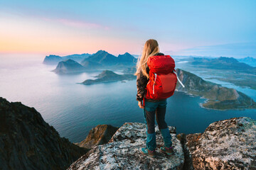Wall Mural - woman mountaineering with backpack solo girl traveling in lofoten islands enjoying aerial view touri