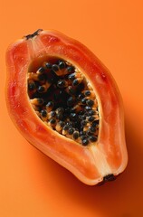 Wall Mural - A slice of orange fruit with black seeds on a table