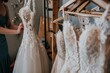 person adjusting a dress on a wooden rack in a bridal shop