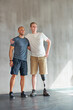 © peopleimages.com - Physiotherapist, man with a disability and prosthetic leg and hug in physiotherapy, studio and gym. Male people, trainer and amputee for wellness, fitness and exercise in rehabilitation center