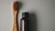Natural Bamboo Toothbrush Next To Dark Glass Bottle On Neutral Surface