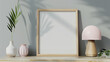 A light wooden frame is placed on the sideboard of an empty room, with a pink lamp and gray wall in the background