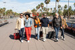 Group of tourist friends with suitcases walking in the city going to hotel or airport 