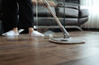 Housewife mopping parquet floor in living room. Hygiene and housekeeping concept