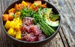 A delectable poke bowl feast showcasing fresh tuna, colorful vegetables, and ripe mango, topped with a sprinkle of black sesame.