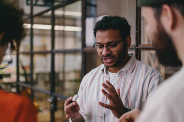 Wall Mural - Crop man speaking with partners in office