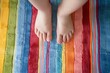 kids feet standing on a multicolored striped bathroom rug