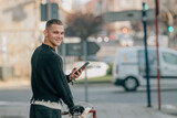 Fototapeta Panele - young man walking on the street with bicycle and mobile phone