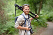 cameraman carrying photographic equipment on his shoulder