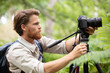 photographer man with professional camera on tripod shooting wildlife