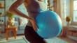 Pregnant woman holding an exercise ball in a sunlit room with plants.