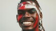 Smiling man with tribal face paint and dreadlocks.