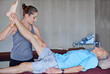 Woman, physiotherapist and stretching leg with patient for joint pain, muscle or leg injury at clinic. Female person or chiropractor helping man for health checkup, arthritis or ache at the hospital