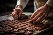 Selective focus on a baker's hands grating chocolate for a recipe.