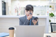 © Lili.Q - White-collar worker sitting at desk and touching up makeup