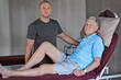 © peopleimages.com - Male, physical therapist and working with senior man and smile in workplace, recovery or support on table. Retired man and physio for assistance and wellness in consulting office, massage or care