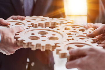 Wall Mural - Business people holding wooden gears in office