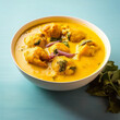 Kadhi Pakora, a flavorful Punjabi dish with deep-fried fritters in tangy yogurt curry, served in a white flat bowl.