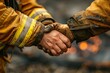 © Woraphon - Two firefighters shake hands in a dirty environment