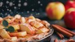 Freshly baked apple pie with cinnamon sticks and apples on a dark surface sugar sprinkling down.