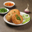 kachori, green chilly and onion slice in plate