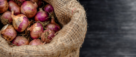 burlap sack filled with red onions on a dark wooden background. culinary ingredients and local produ