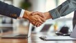 Handshake above office desk - Satisfied client and company worker closing business deal and confirming cooperation