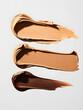 Three different shades of foundation are displayed on a clean white background