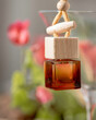 Car air perfume freshener. Little glass bottle with wooden lid. Aromatic liquid in the small bottle.  Selective focus