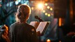 © Татьяна Макарова - A woman is seen from behind, reading aloud into a microphone under stage lighting.