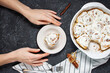 Woman's hands cut the Cinnamon rolls or cinnabon, homemade recipe of sweet traditional dessert buns. Top view