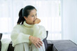 Woman spend time at home seated on sofa