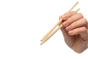 Wall Mural - Female hand holding wooden sushi chopsticks isolated on white background.