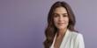 © Viktor - A woman with long brown hair is seen wearing a white blazer while posing in front of a purple background