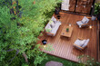 Aerial view of modern contemporary style small wooden terrace in lush garden with 3d render, decorated with white outdoor furniture and string light