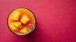 Fresh summer tropical fruit drink. Mango smoothie or juice, non alcohol, healthy drink, with slice fresh mango and papaya on pink background. Copy space top view. isolated