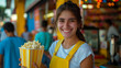 Smiling teenage girl with popcorn enjoying a day at the amusement park.