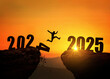 © alones - Man jumping on cliff 2025 over the precipice with stones at amazing sunset. New Year's concept. 2024 falls into the abyss. Welcome 2025. People enters the year 2025, creative idea.
