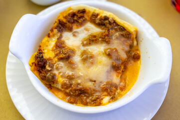 Wall Mural - Traditional first course for lunch or dinner in Italy, lasagne Bolognese with beef meat and bechamel sauce served in Italian restaurant, Milan, Italy