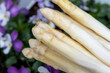 Spring season, new harvest of Dutch, German white asparagus, bunch of raw washed and pilled white asparagus and viola flowers