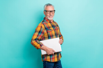 Poster - Photo of attractive retired man wear plaid shirt spectacles holding modern gadget isolated turquoise color background