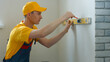 © DenisProduction.com - Worker draws markings on the wall. Lines are drawn for fastening.