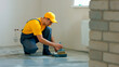 © DenisProduction.com - The builder primes the floor. Worker make renovation of apartment.