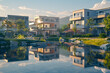 A crisp morning view of modern houses reflecting early sunlight in a landscaped neighborhood. /