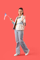 Canvas Print - Young woman with USA flag waving hand on red background