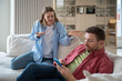 © DimaBerlin - Hysterical excited woman blaming, shouting at uncaring indifferent lazy man sitting on sofa with smartphone. Wife regrets of wedding, creating family because husband doesnt satisfy expectations