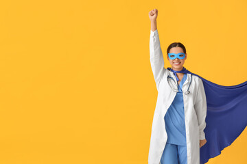 Poster - Young female doctor in superhero costume on yellow background