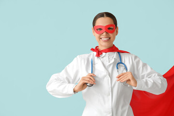 Poster - Young female doctor in superhero costume on blue background